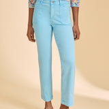 Blue ankle pant paired with patterned top against beige background