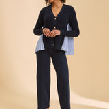 Woman wearing a navy outfit with a beige background