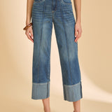 Person wearing blue jeans and a striped shirt on a beige background