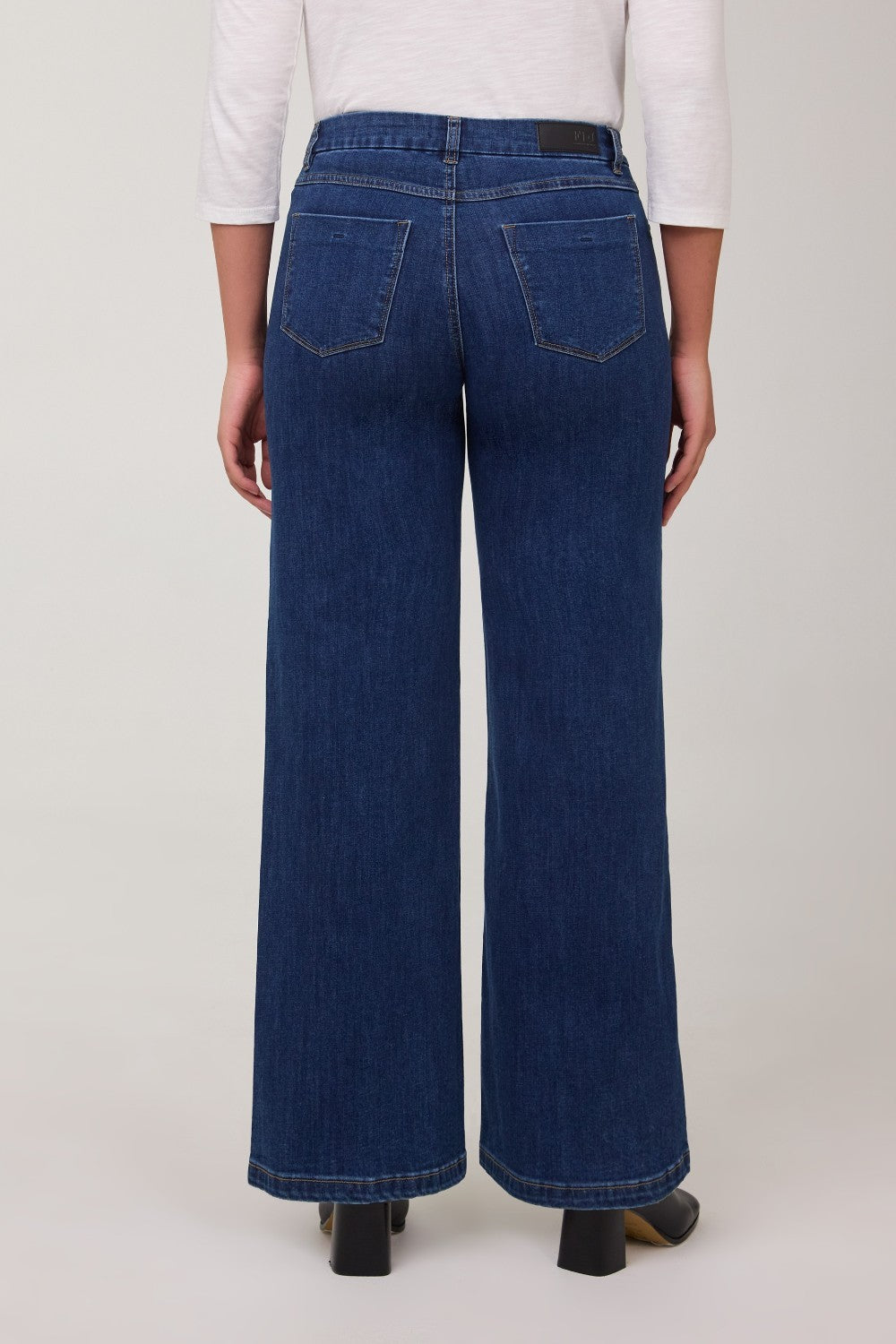 Person wearing blue wide-leg jeans on a white background
