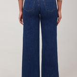 Person wearing blue wide-leg jeans on a white background