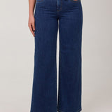 Person wearing blue wide-leg jeans on a white background