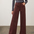 Person wearing a wide leg pant with a patterned top and pumps on a neutral background.