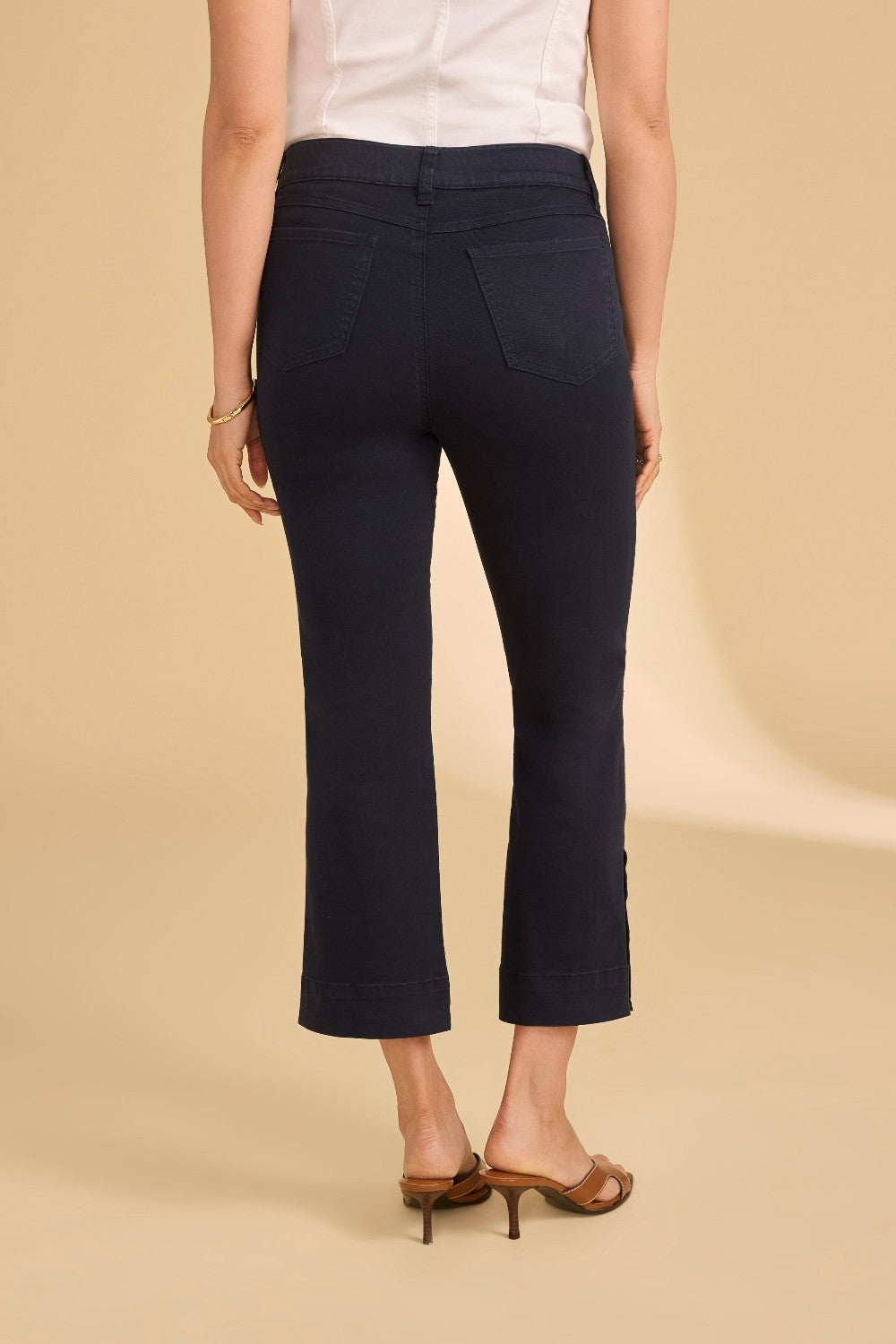 Person wearing navy pants on a beige background