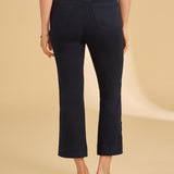 Person wearing navy pants on a beige background