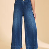 Person wearing blue wide-leg jeans and a striped shirt on a beige background