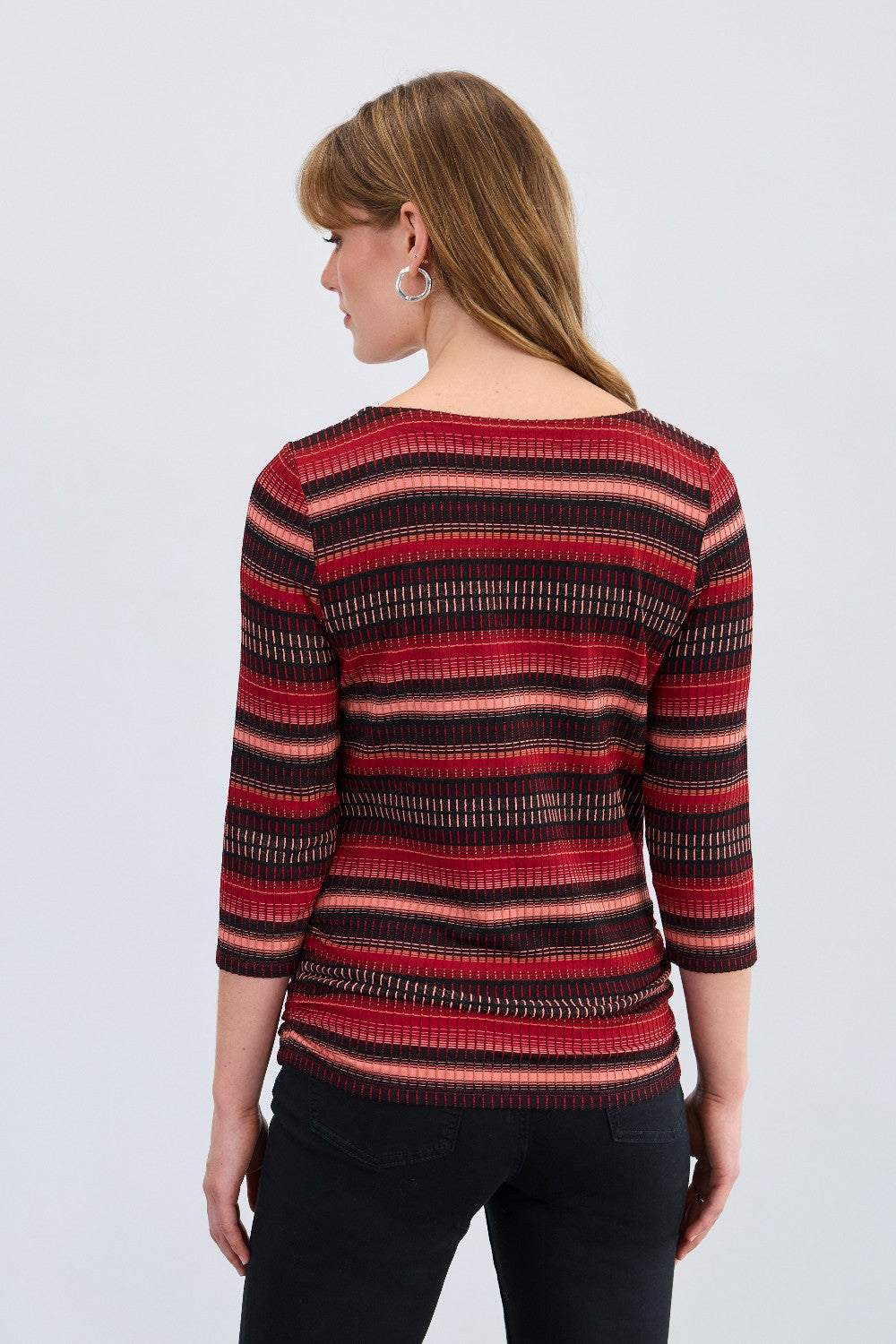 Woman wearing a red and black striped top on a white background
