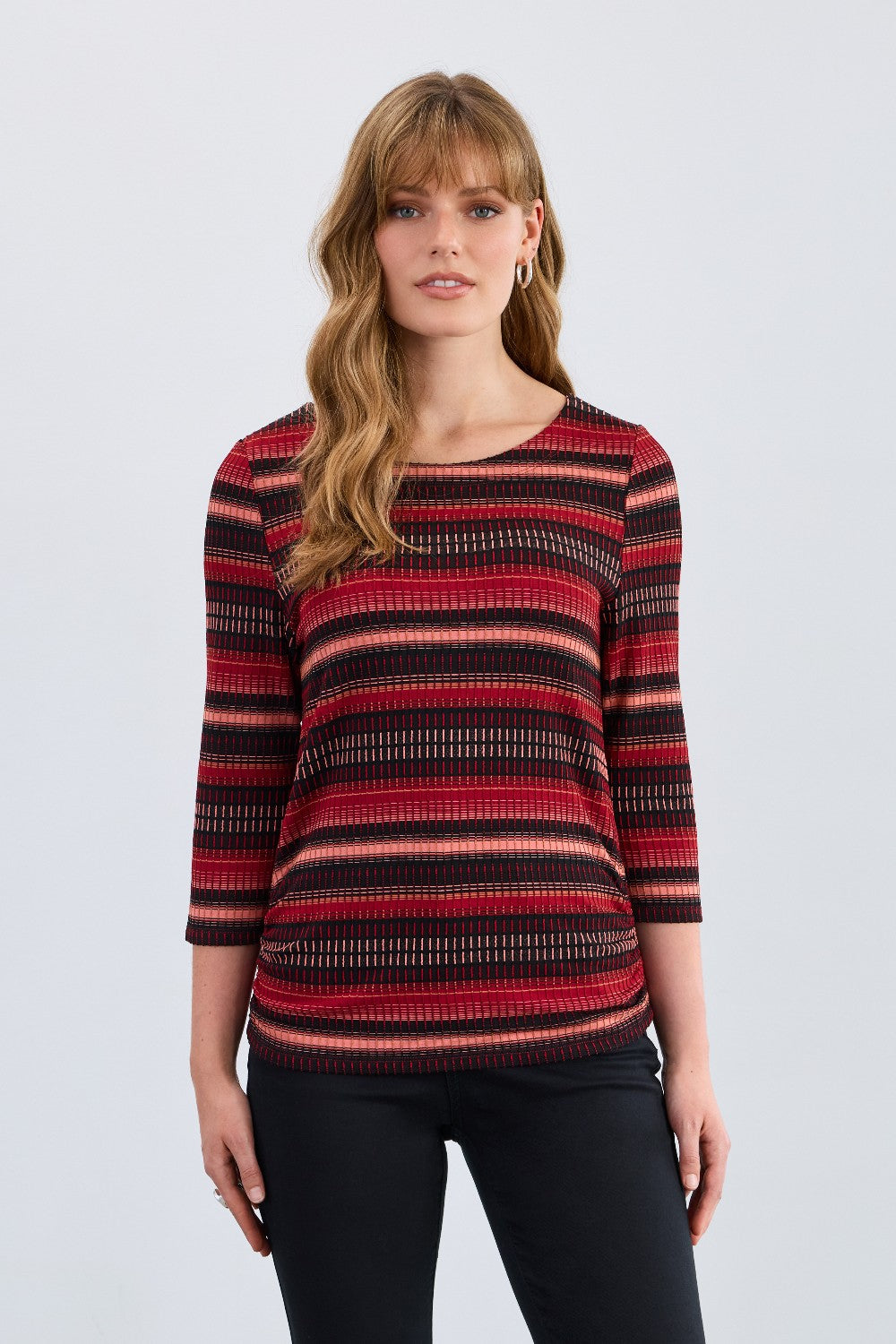 Woman wearing a red and black striped top on a white background