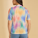 Person wearing a colorful shirt against a beige background