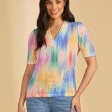 Woman wearing a colorful shirt and jeans on a beige background
