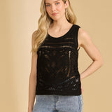 Woman wearing a black sleeveless top with crochet details against a beige background