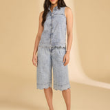 Woman wearing a denim outfit on a beige background