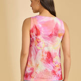 Woman wearing a sleeveless, multicolored tie-dye top against a beige background