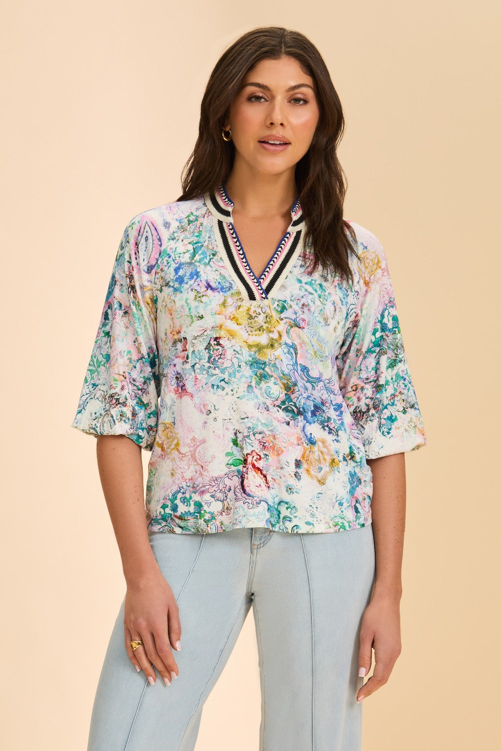 Woman wearing a floral blouse with a beige background
