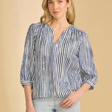 Woman wearing a blue and white striped shirt against a beige background