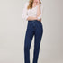 Woman wearing blue jeans and a white top on a plain background