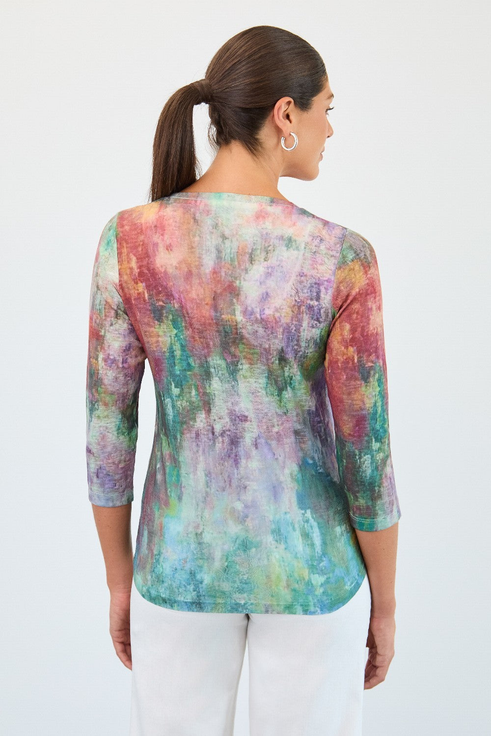 Woman wearing a colorful tie-dye shirt on a white background