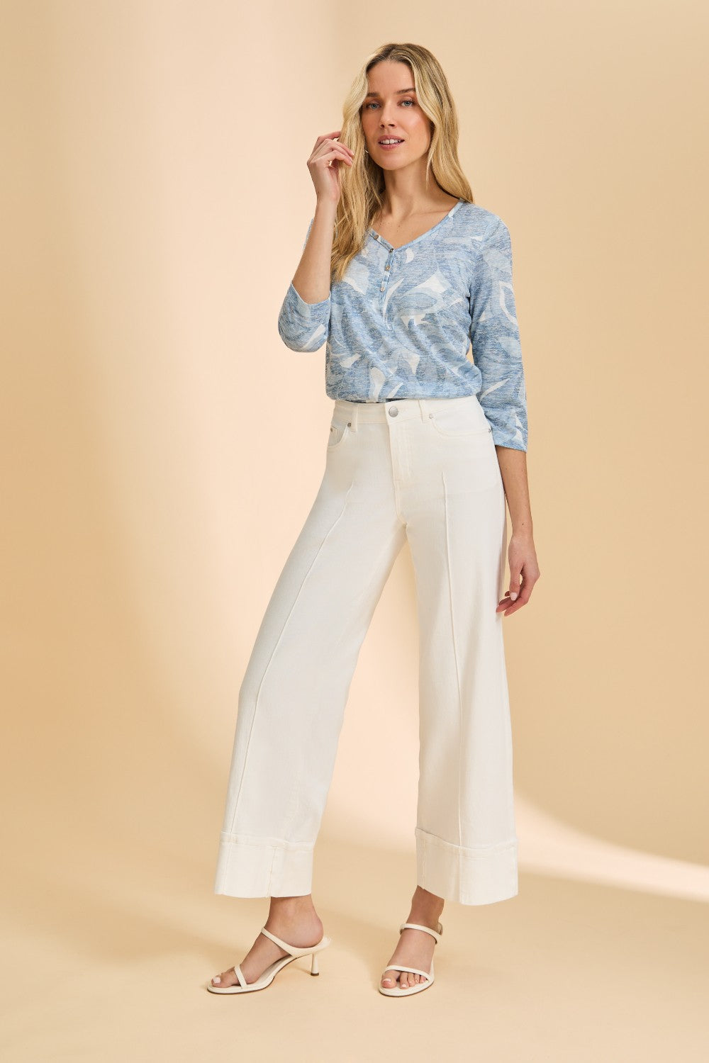 Woman wearing blue pattered top with wide leg cream coloured pant