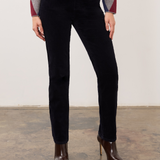 Person wearing a dark blue straight leg corduroy pant with a grey, blue and burgundy argyle print sweater and brown high heel boots on a neutral background.