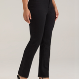 A model wearing black high-waisted straight-leg jeans, styled with a white top and black pointed-toe heels, photographed against a neutral light gray studio background.