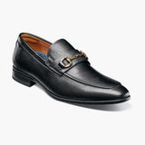 Black leather loafer with a gold buckle on a white background