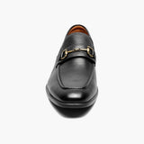 Black leather loafer with gold buckle on a white background
