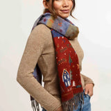 Woman wearing Christmas themed scarf with beige sweater and blue jeans on light background
