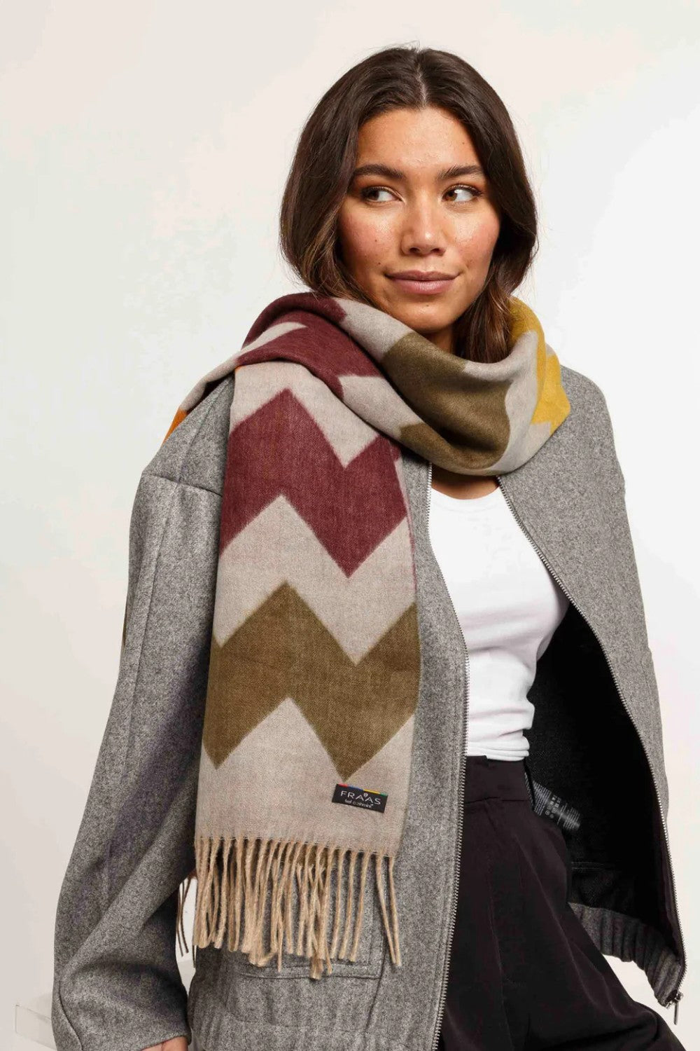 Woman wearing a patterned scarf with a plain background