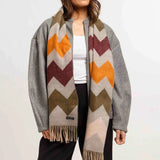 Woman wearing a colorful chevron-patterned scarf with a gray border on a white background