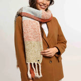 Woman wearing a brown coat and colorful scarf on a white background