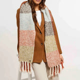 Woman wearing a colorful scarf and brown coat on a white background