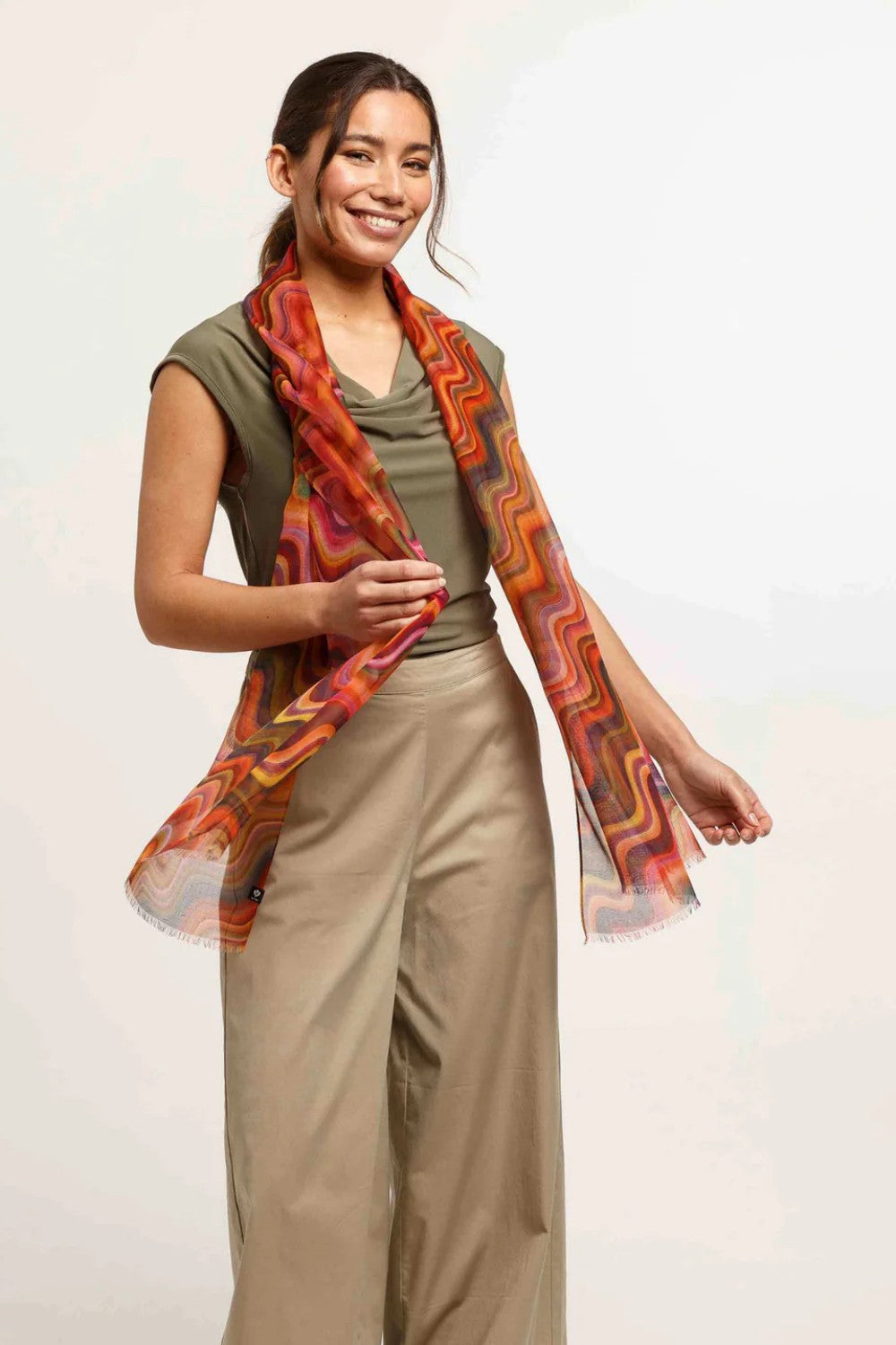 Woman wearing a patterned scarf with a plain background