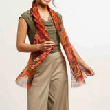 Woman wearing a patterned scarf with a plain background