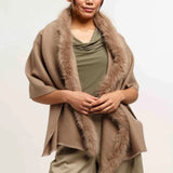 Woman wearing a brown shawl with fur trim on a white background