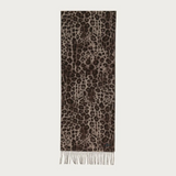 A vertical scarf with an all-over leopard print pattern in brown, beige, and black, finished with fringe at the bottom, shown against a solid off-white background.
