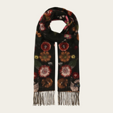 A black scarf with a detailed floral pattern in red, orange, and green, finished with fringe on both ends, displayed against a light off-white background.