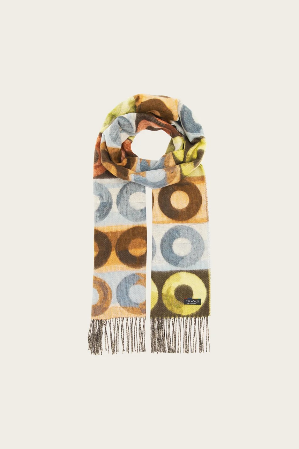 Scarf featuring a pattern with multi coloured circles and fringe photographed against a light background.