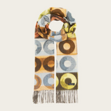 Scarf featuring a pattern with multi coloured circles and fringe photographed against a light background.