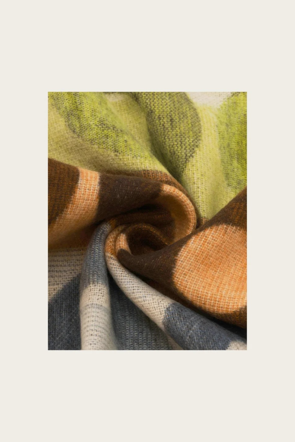 Close up of a scarf featuring multi colours photographed against a light background.