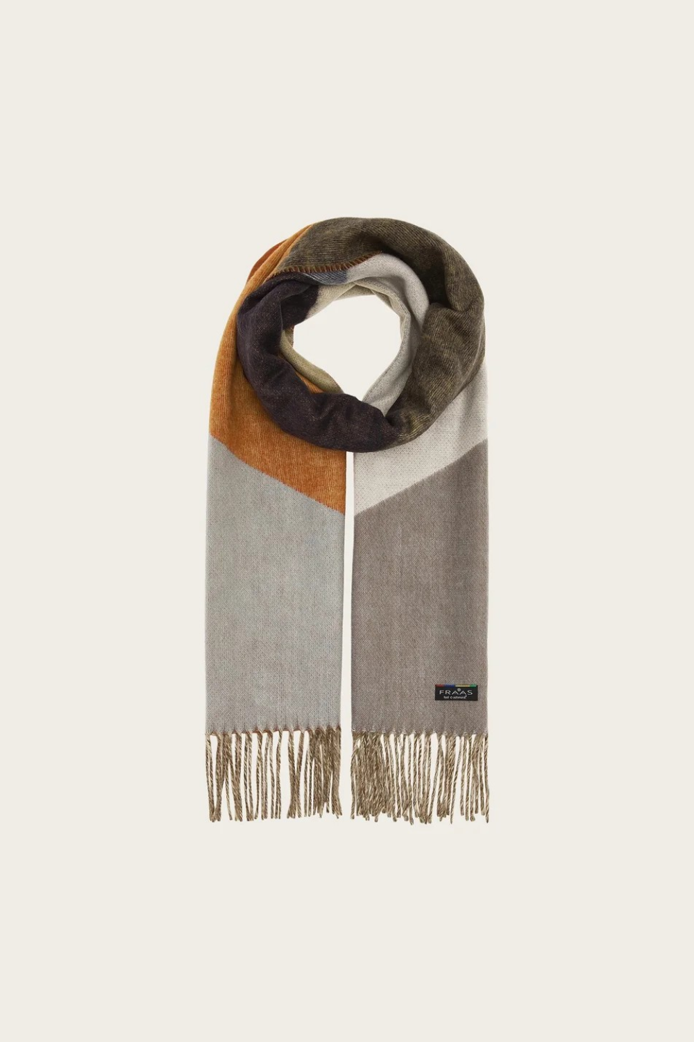 A colour block scarf with browns, greys and oranges, and fringe, photographed against a light backdrop.