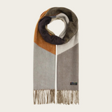 A colour block scarf with browns, greys and oranges, and fringe, photographed against a light backdrop.