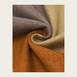 Close up of a multi coloured fabric photographed against a light backdrop.