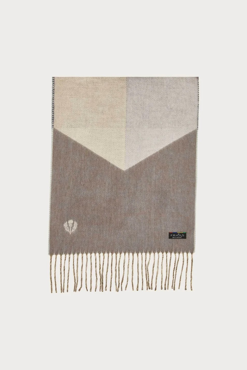 A colour block scarf with browns, greys,  and fringe, photographed against a light backdrop.