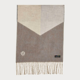 A colour block scarf with browns, greys,  and fringe, photographed against a light backdrop.