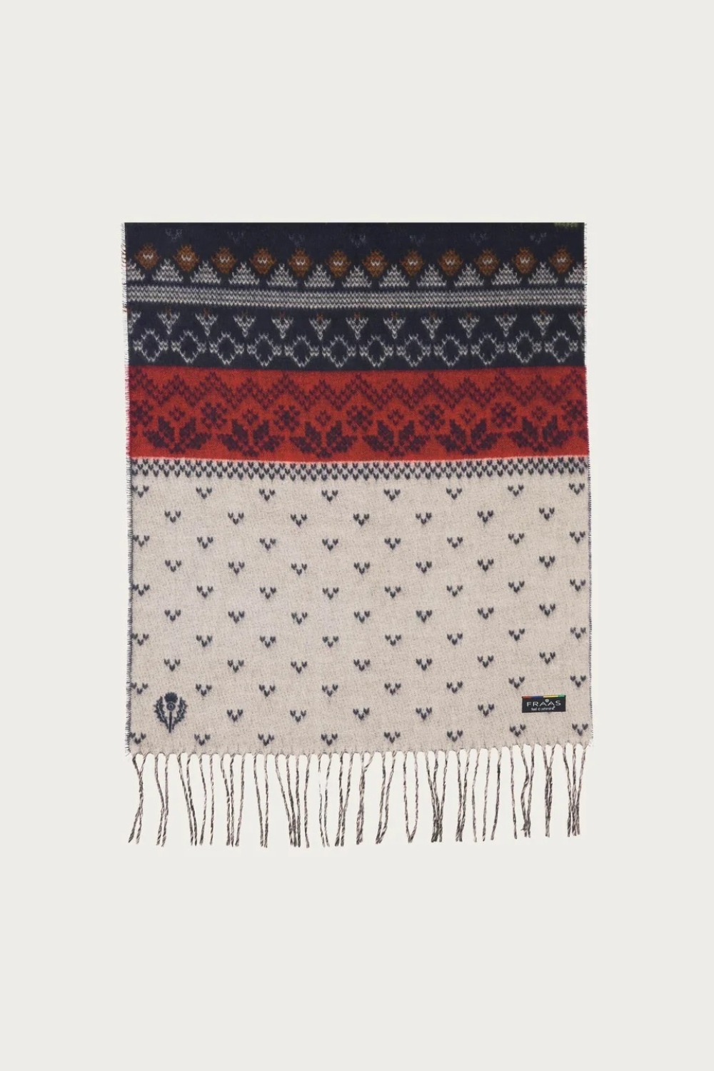 A multi coloured winter themed scarf with fringe photographed against a light backdrop.