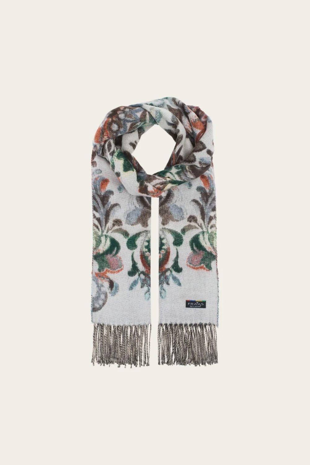 A multi coloured floral scarf, with fringe, photographed against a light background.