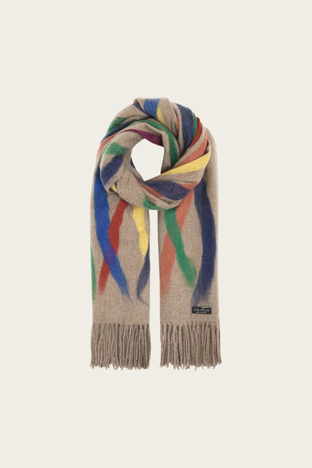 A beige based scarf with multi coloured brushstoke patterns, and fringe, photographed against a light backdrop.