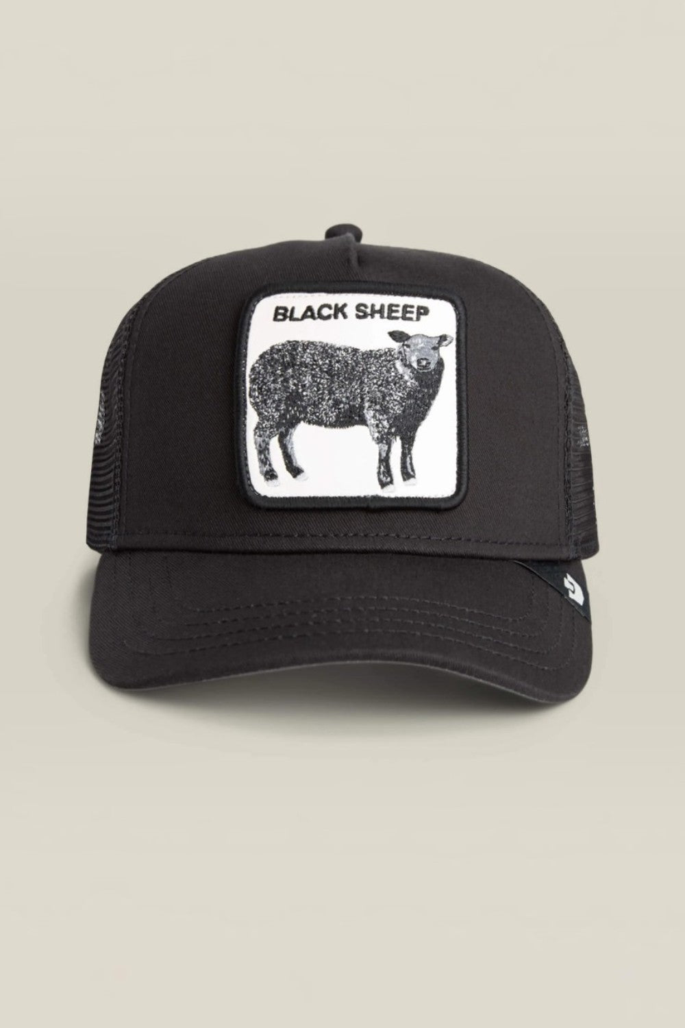 A black trucker-style cap with a white rectangular patch on the front featuring a black sheep illustration and the text 'BLACK SHEEP'.