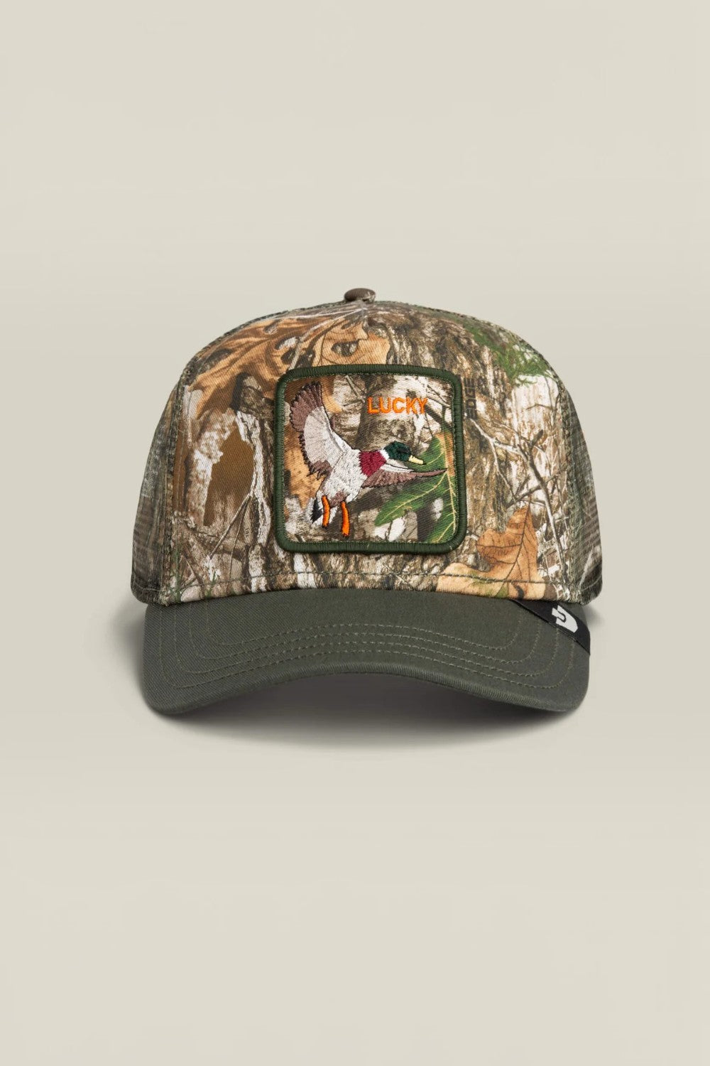 A camouflage trucker cap with a dark olive green brim and mesh back, featuring a rectangular front patch with a duck hunting illustration and the word 'Duck Hunt'.