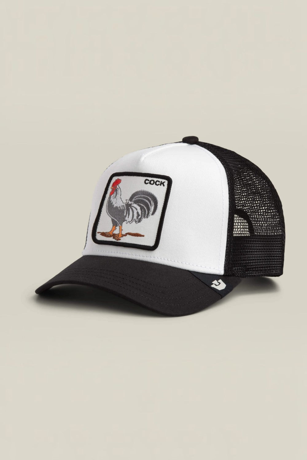 A black and white trucker hat featuring a square patch on the front with a rooster illustration and the word 'COCK'. The hat has a white front panel, black brim, and black mesh back.